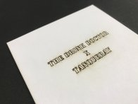 Découpe traversant le carton blanc d'une invitation : effet brûlé qui donne toute son originalité au support. Certai