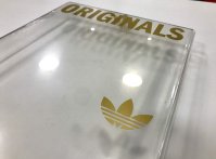 Gold adhesive lettering on clear plexiglass box for Adidas